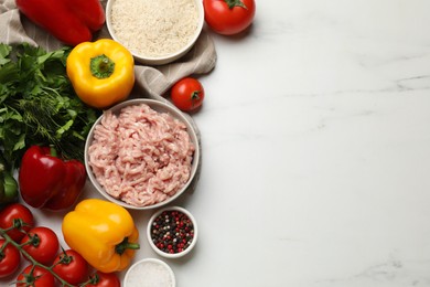 Making stuffed peppers. Ground meat and other ingredients on white marble table, flat lay. Space for text