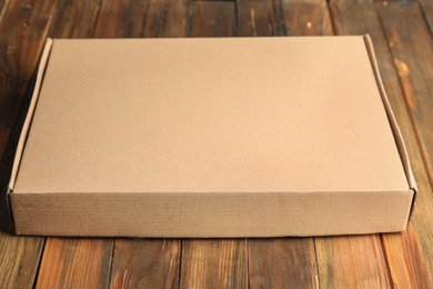 Closed cardboard box on brown wooden table