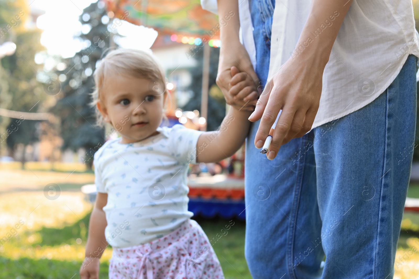 Photo of Mother with cigarette and child outdoors, closeup. Don't smoke near kids