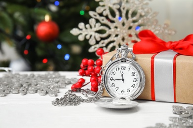 Photo of Pocket watch, gift and festive decor on table. Christmas countdown