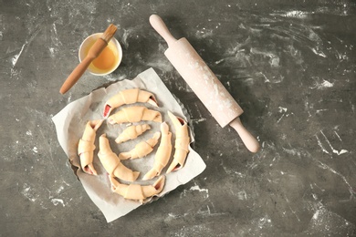 Photo of Baking dish with raw croissants on table, top view