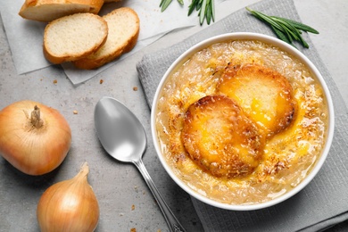 Tasty homemade french onion soup served on grey table, flat lay