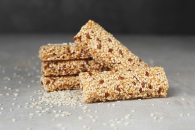 Tasty sesame seed bars on grey table