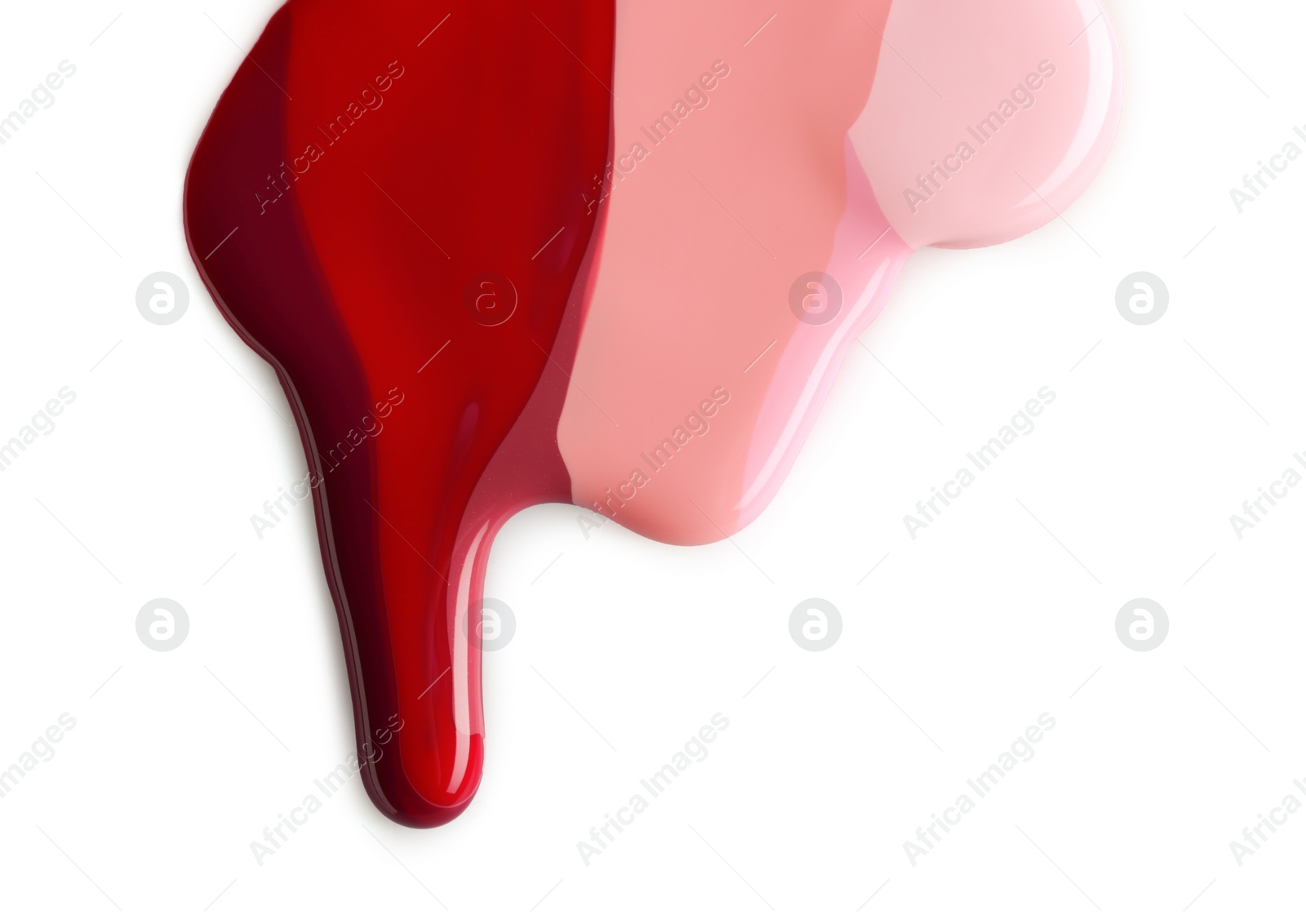 Photo of Spilled different nail polishes on white background, top view