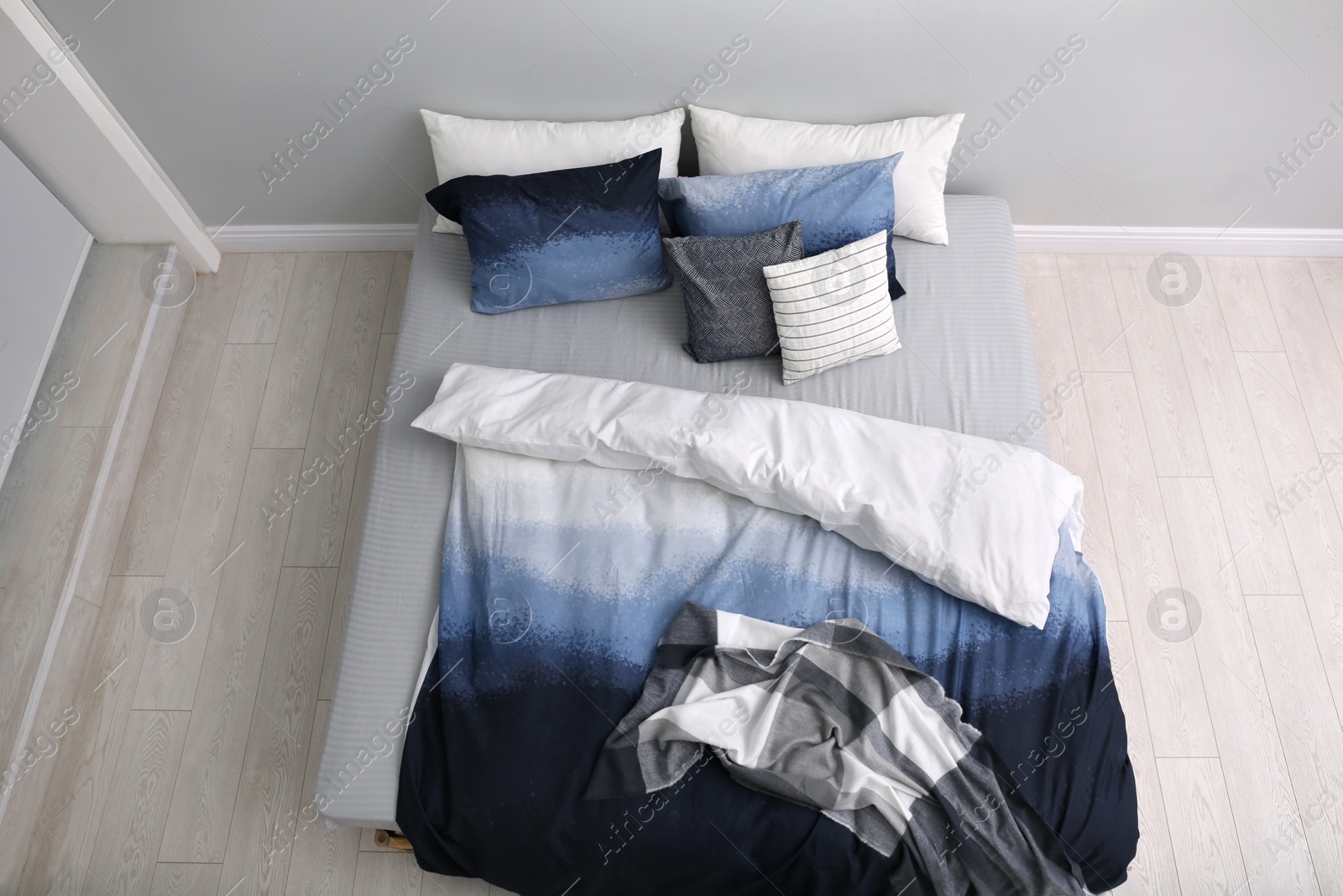 Photo of Large bed with stylish linens in room, above view