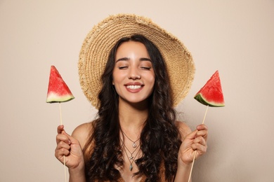 Photo of Beautiful young woman with watermelon on beige background