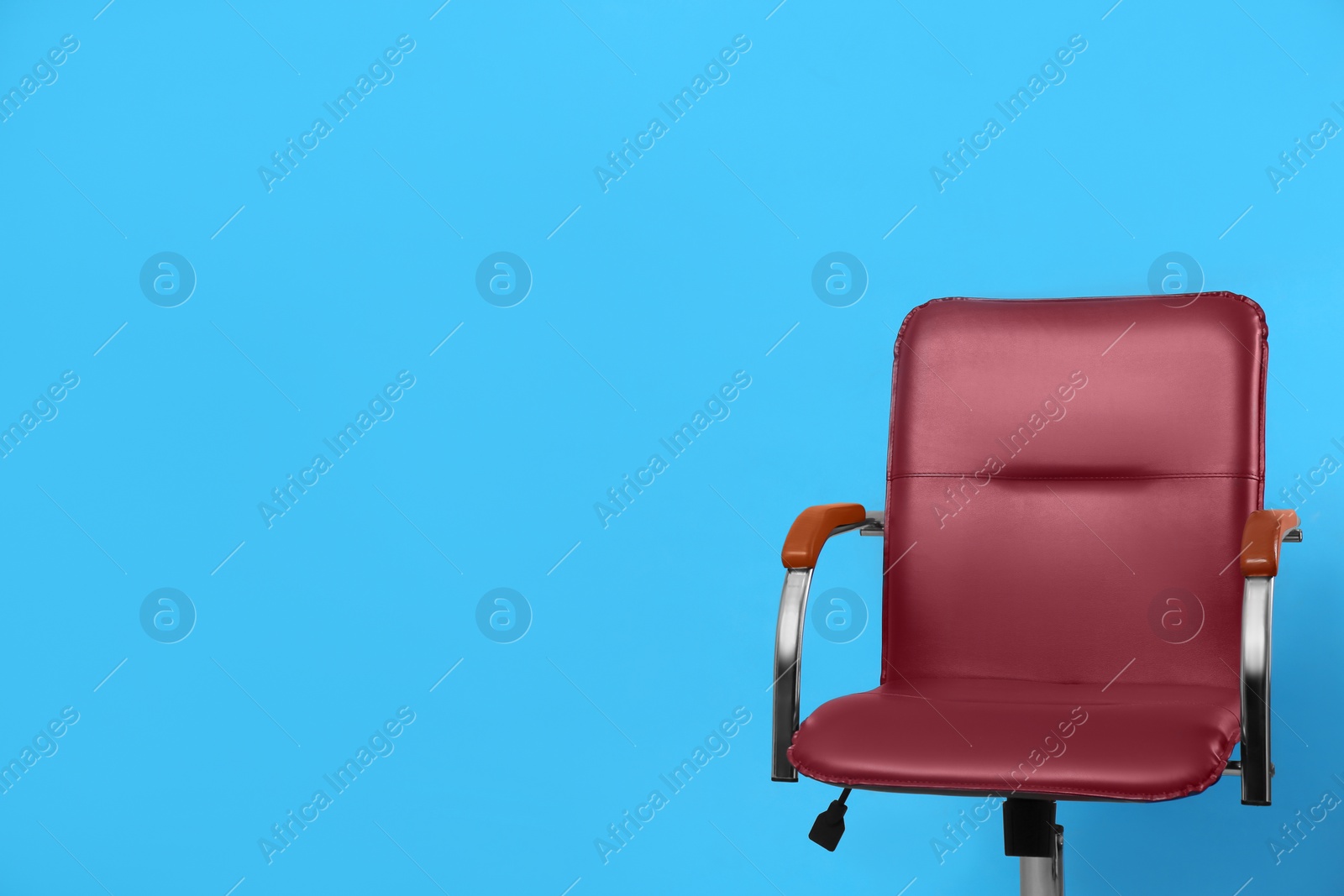 Photo of Comfortable office chair on light blue background, space for text