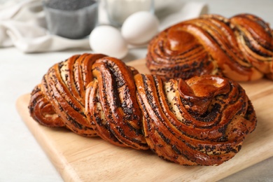 Photo of Tasty sweet buns with poppy seeds on gray table