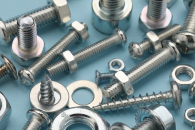 Photo of Many different fasteners on light blue background, closeup