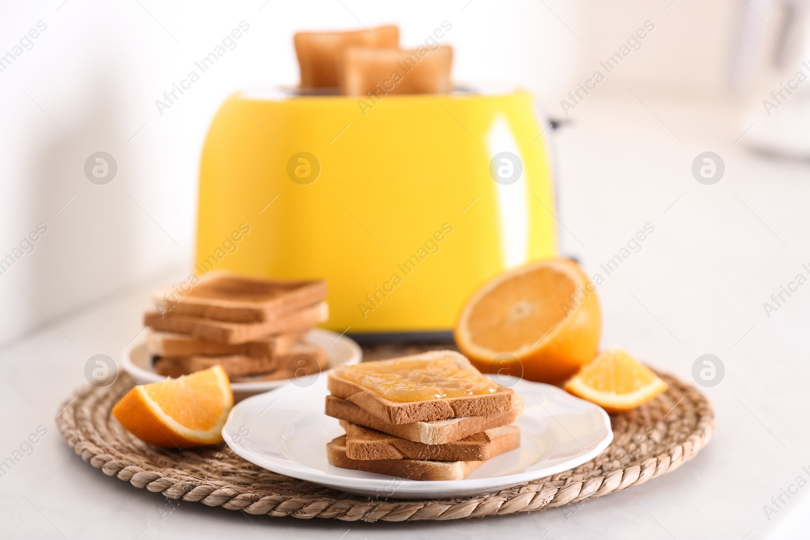 Photo of Modern toaster and delicious breakfast on table in kitchen