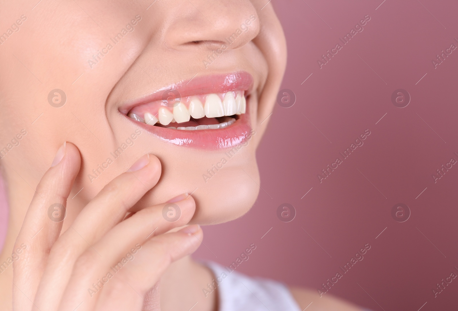 Photo of Young woman with healthy teeth and beautiful smile on color background, closeup. Space for text