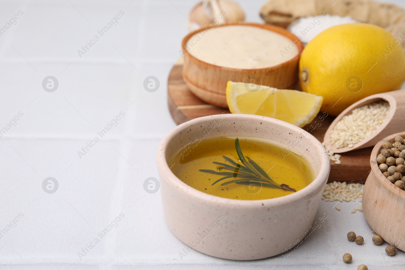 Photo of Different fresh ingredients for marinade on white tiled table, closeup. Space for text