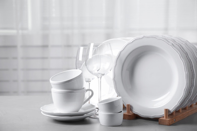 Photo of Set of clean tableware on light grey table