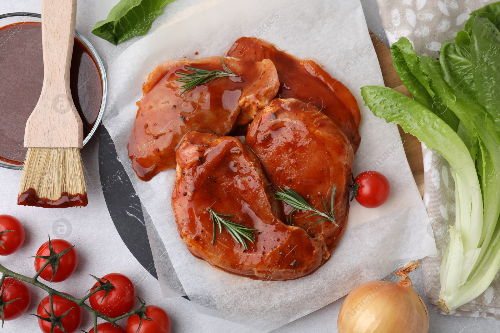 Photo of Flat lay composition with raw marinated meat, products and basting brush on white table