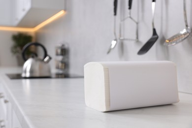 Photo of Package of paper towels on white countertop in kitchen. Space for text