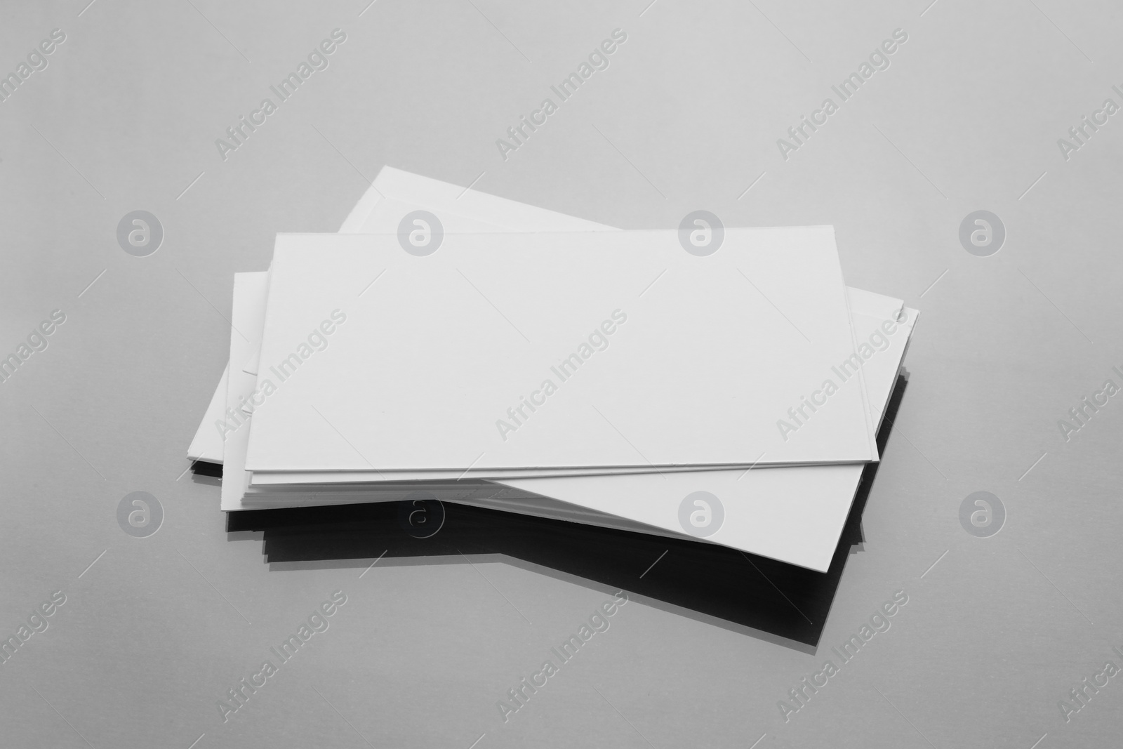 Photo of Blank business cards on mirror surface. Mockup for design