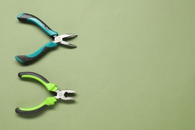 Pliers on olive background, flat lay. Space for text