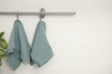 Photo of Clean kitchen towels hanging on rack. Space for text