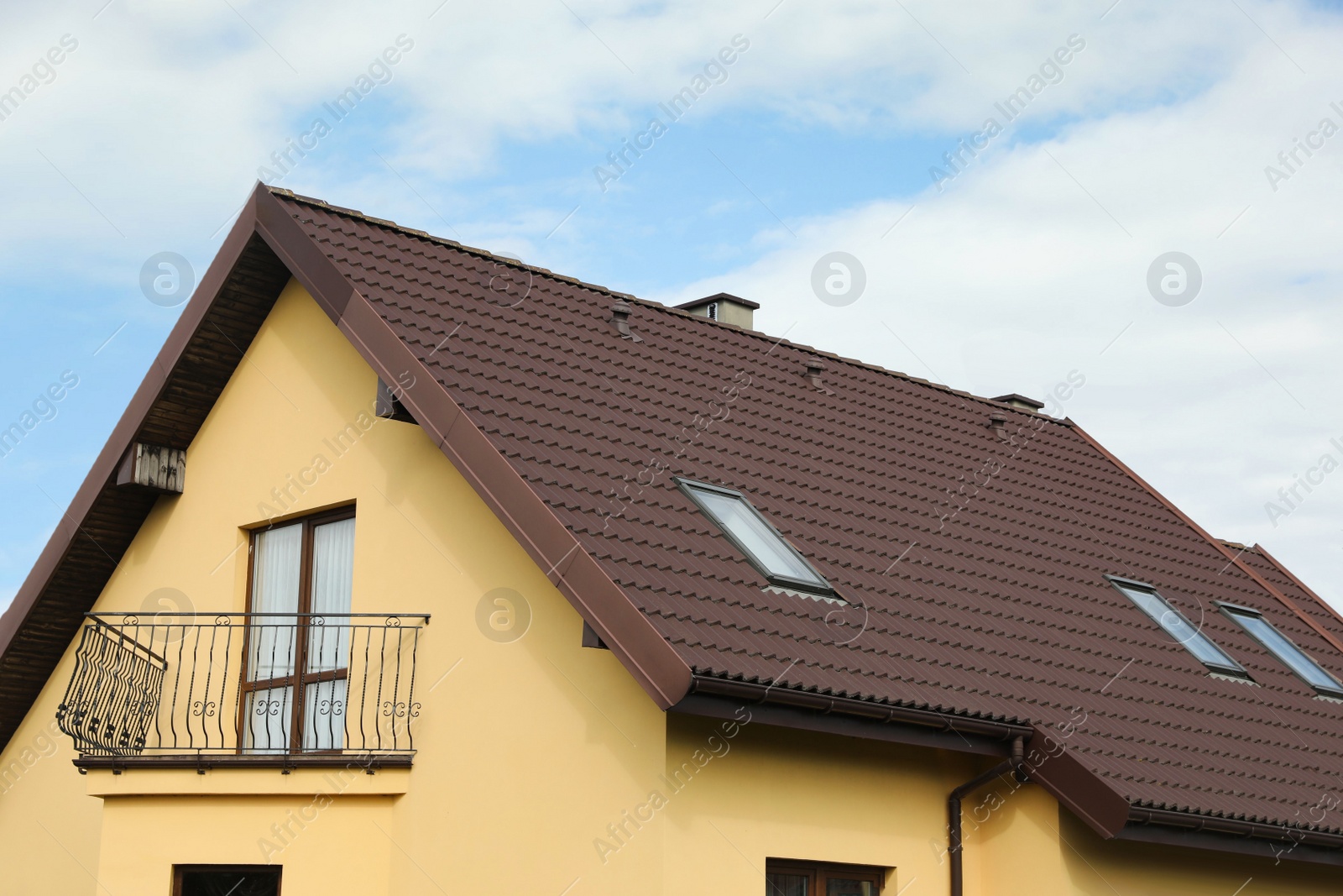 Photo of Modern house with brown roof against cloudy sky