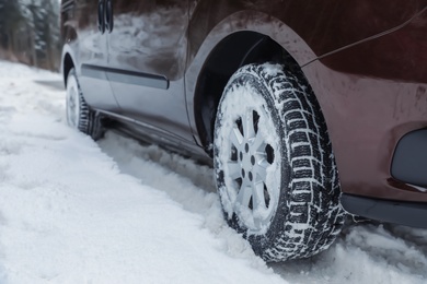 Photo of Closeup view of car in snow near road. Space for text