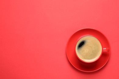 Photo of Cup of aromatic coffee on red background, top view. Space for text