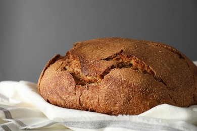 Photo of Freshly baked sourdough bread on table against grey background, closeup