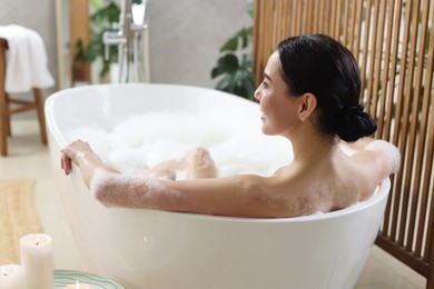 Photo of Beautiful young woman taking bubble bath at home