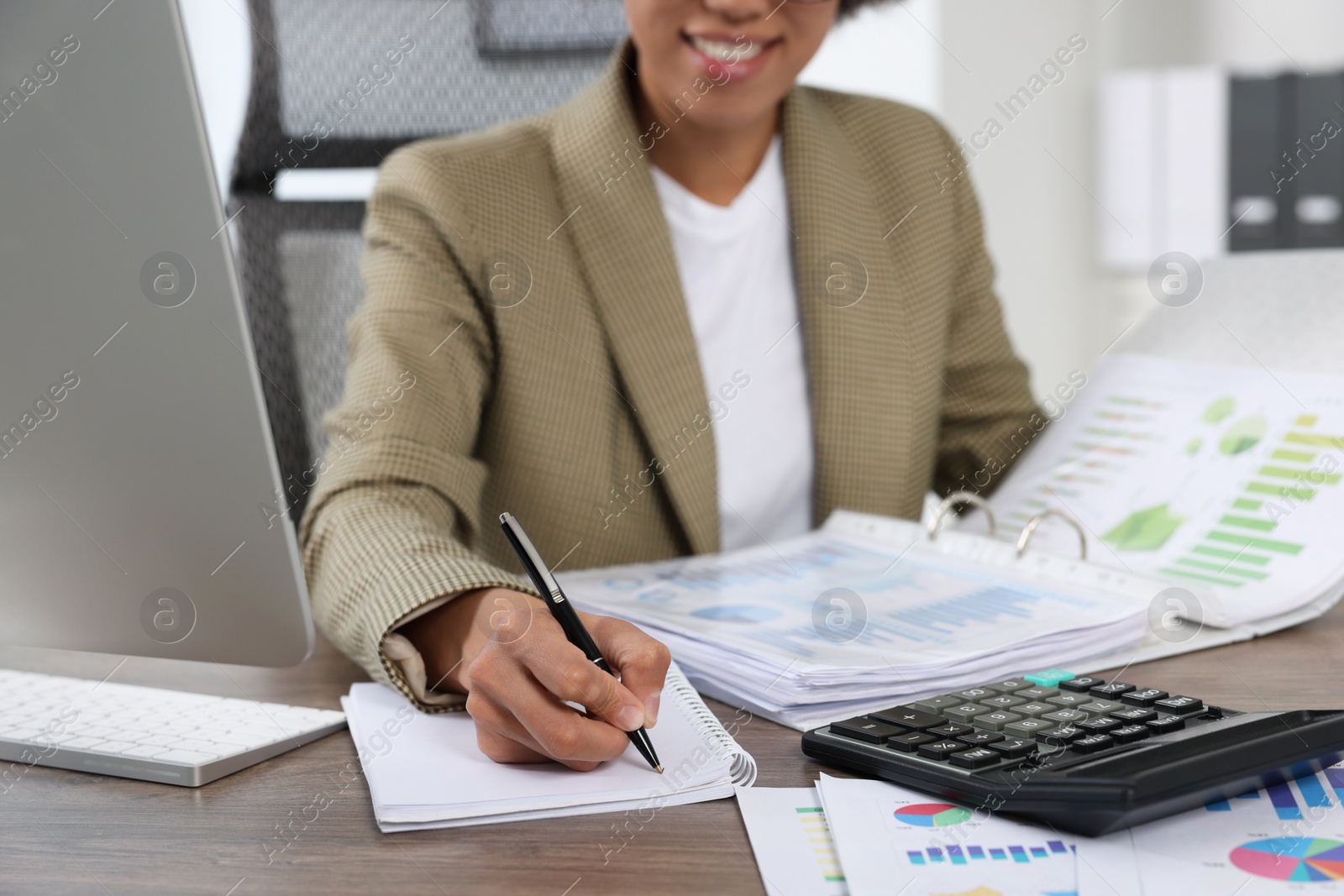 Photo of Professional accountant working at wooden desk in office, closeup