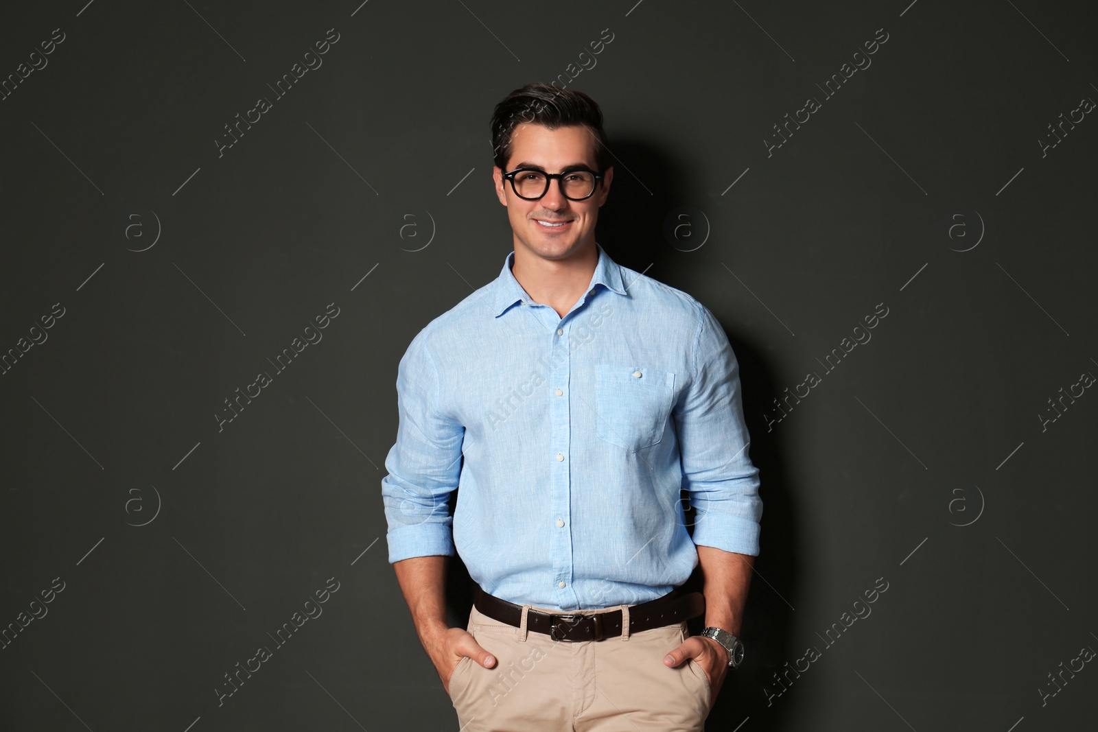 Photo of Handsome young man in stylish clothes with glasses on dark background