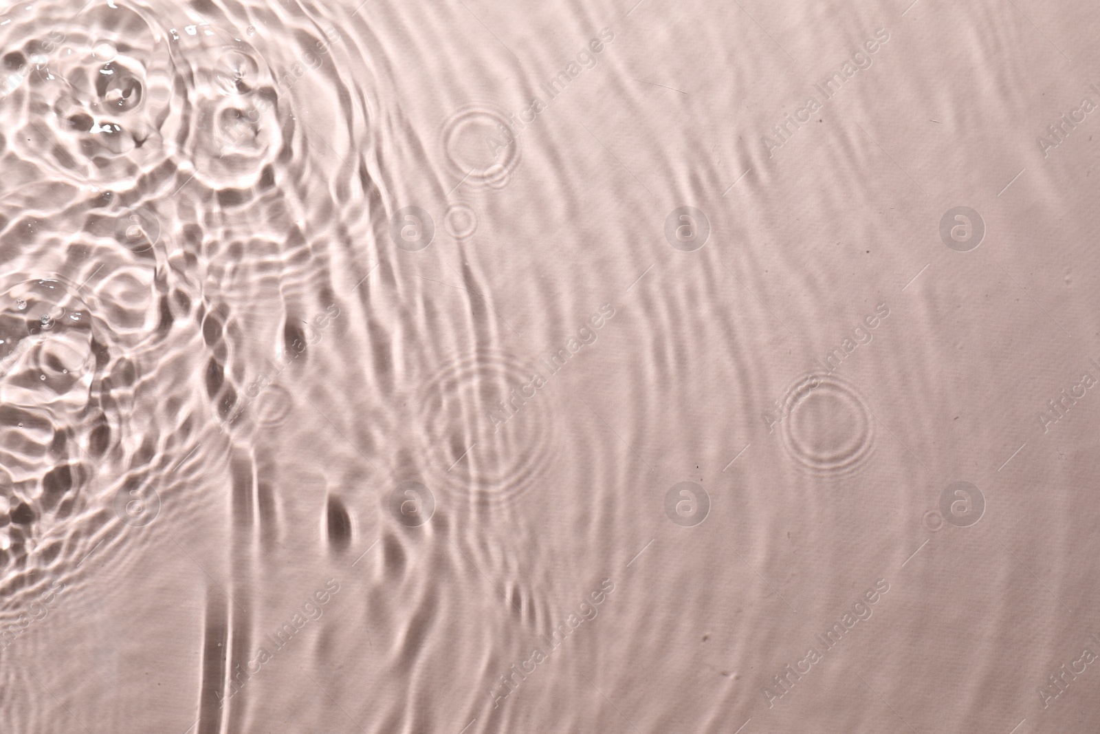 Photo of Rippled surface of clear water on beige background, top view