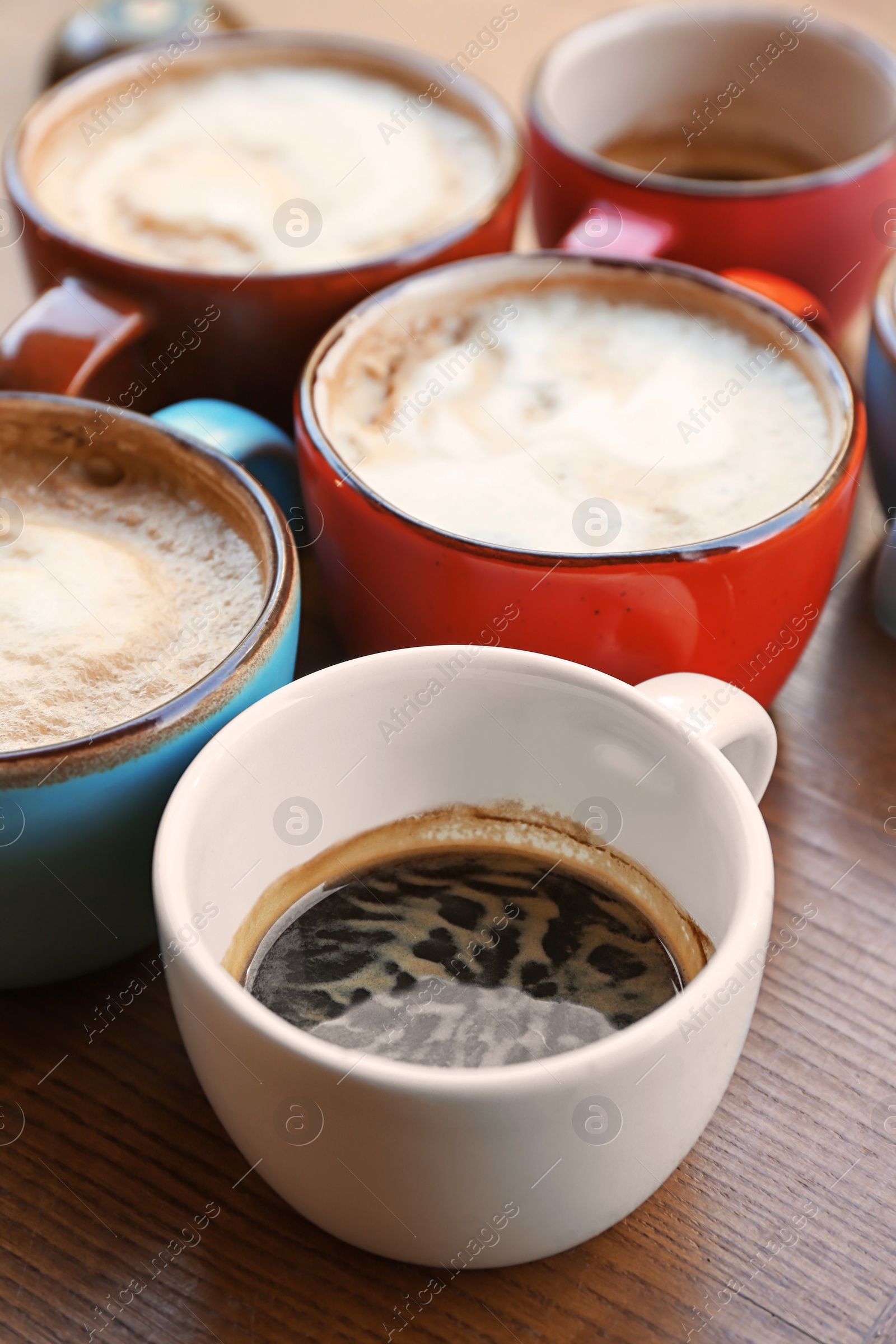 Photo of Cups of fresh aromatic coffee on wooden table