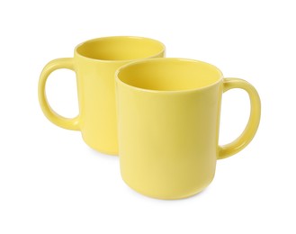 Two yellow ceramic mugs isolated on white