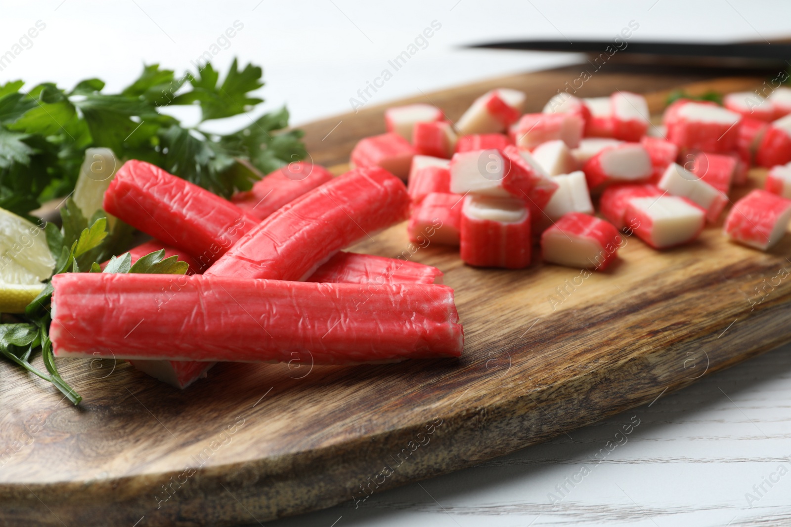 Photo of Delicious crab sticks on wooden board, closeup