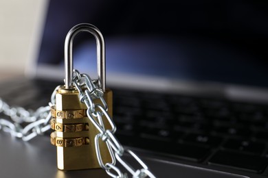 Photo of Cyber security. Padlock with chain on laptop, closeup