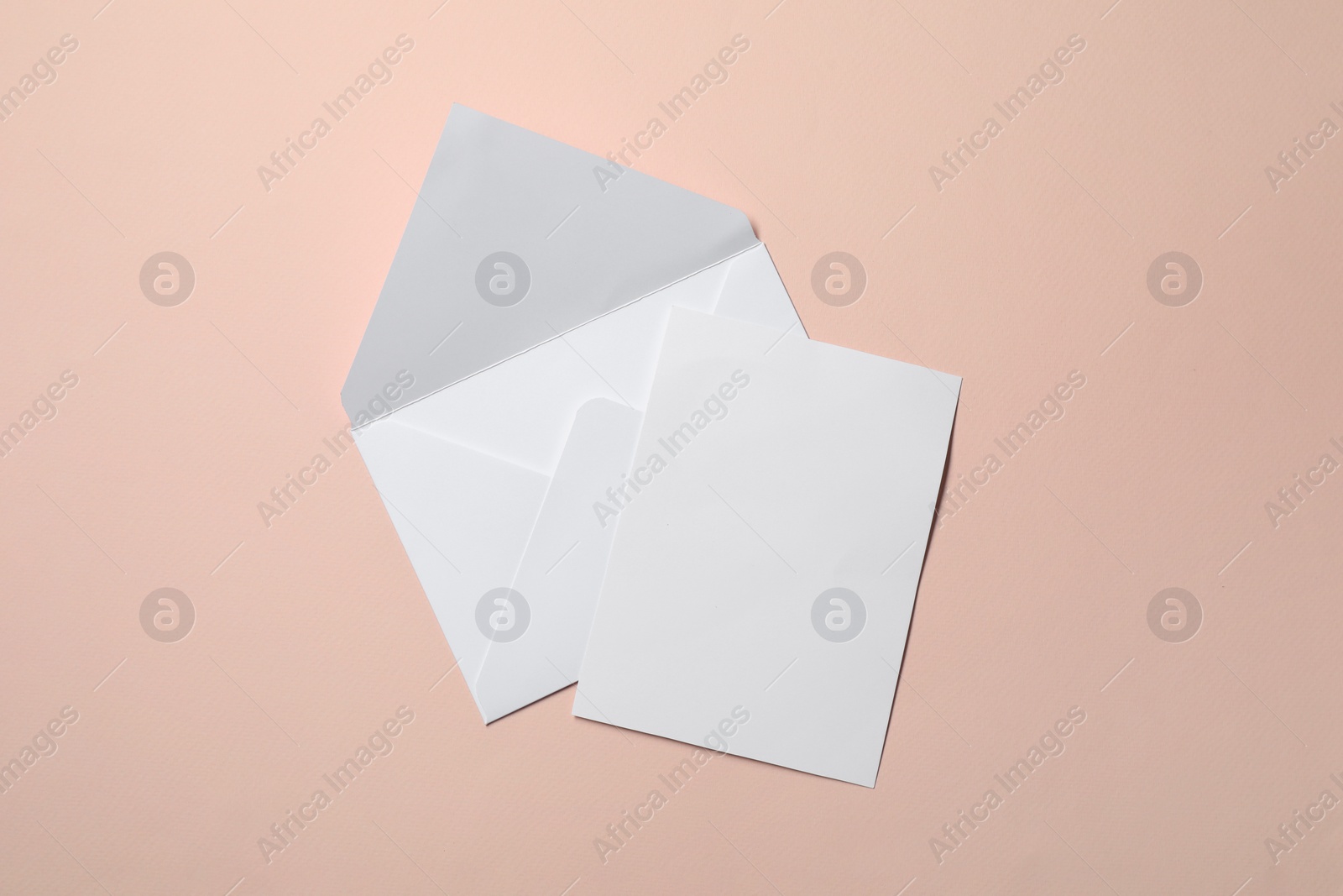 Photo of Letter envelope and card on beige background, top view. Space for text