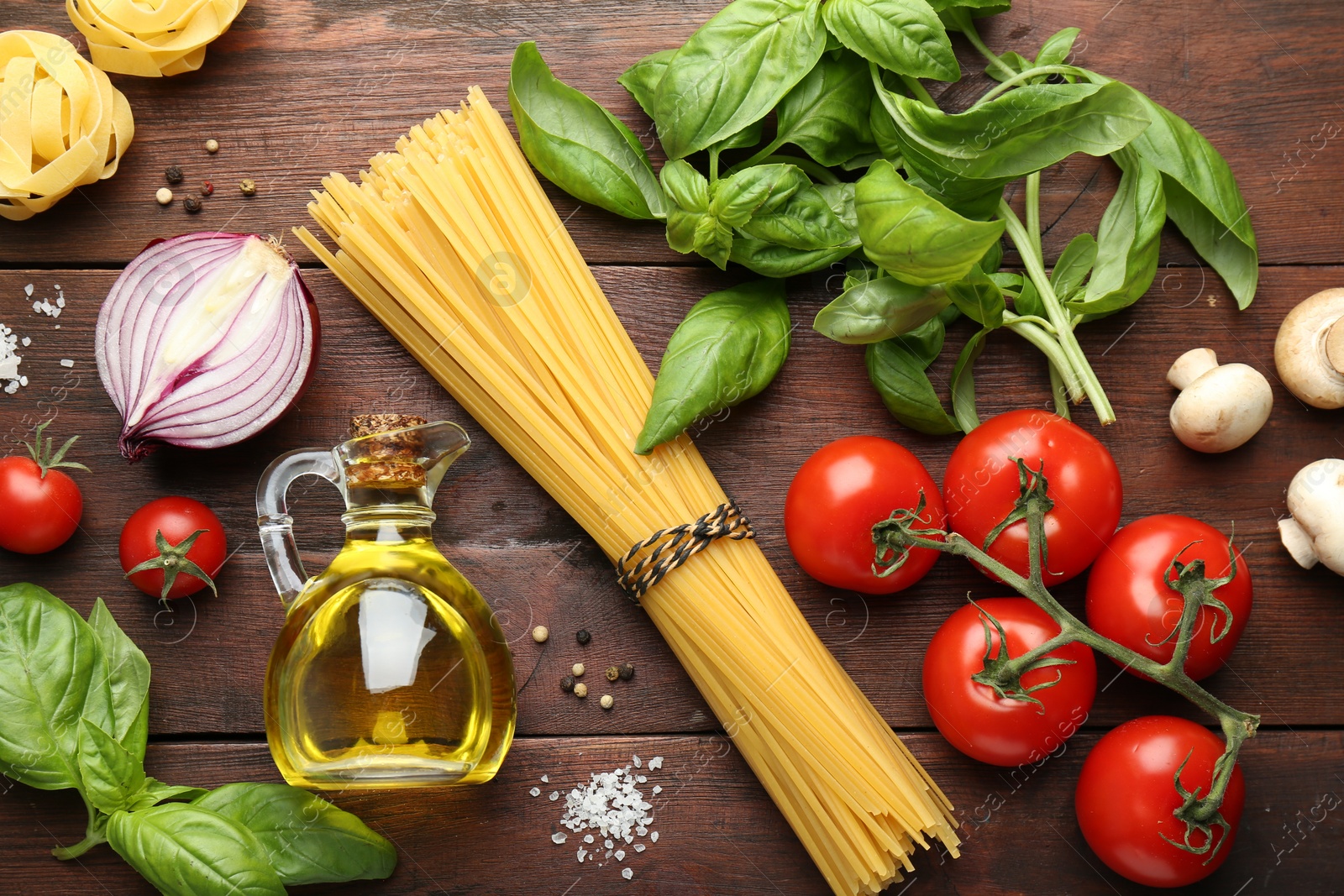 Photo of Different types of pasta, spices and products on wooden table, flat lay