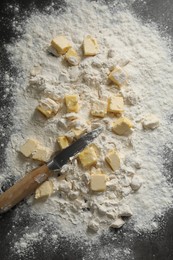 Photo of Making shortcrust pastry. Flour, butter and knife on grey table, top view