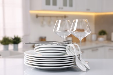 Set of clean dishware, glasses and cutlery on table in kitchen