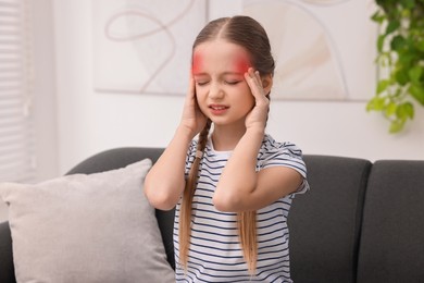 Little girl suffering from headache at home