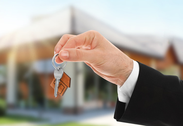 Image of Man with key near new modern house outdoors, closeup