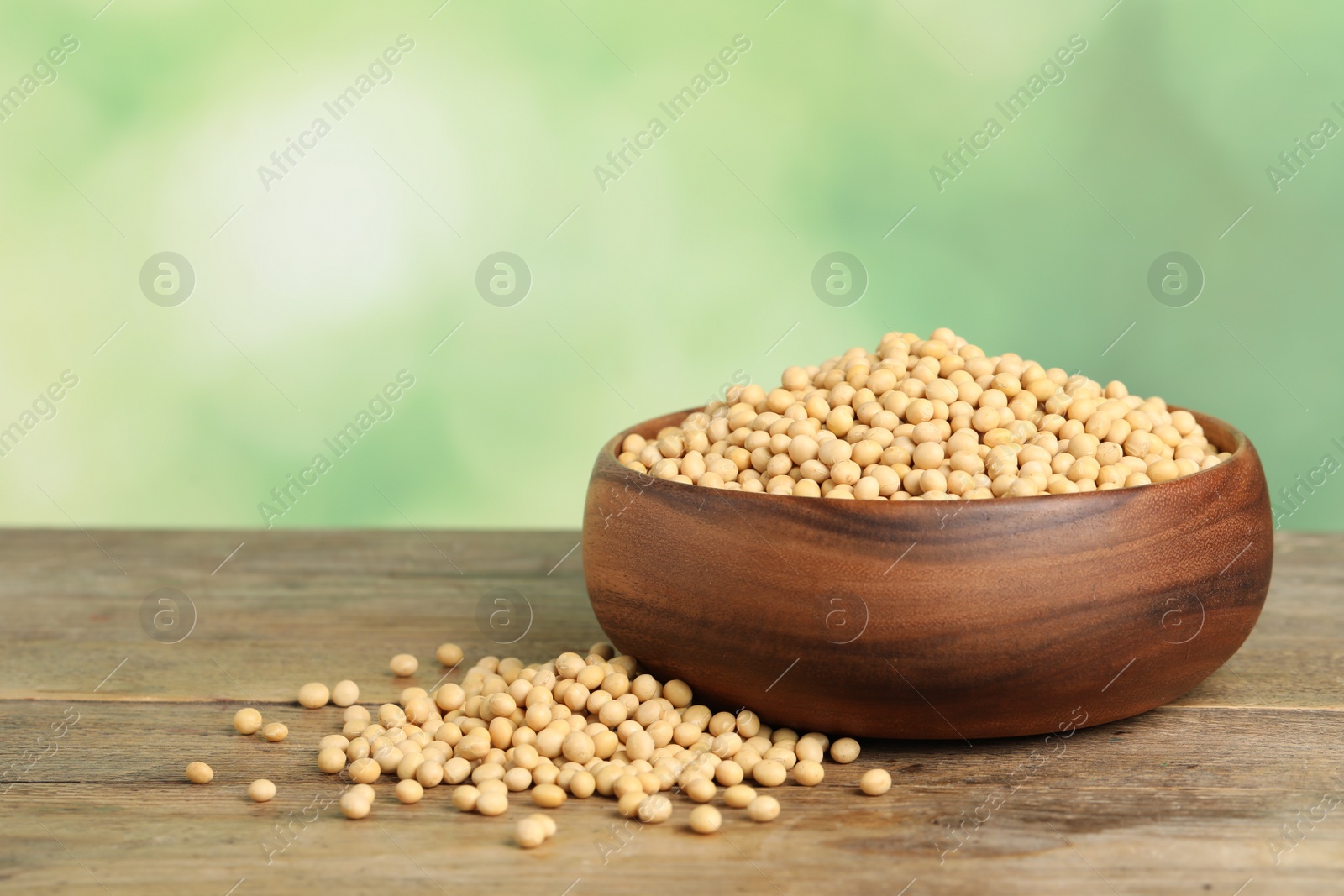 Photo of Natural soy beans on wooden table. Space for text
