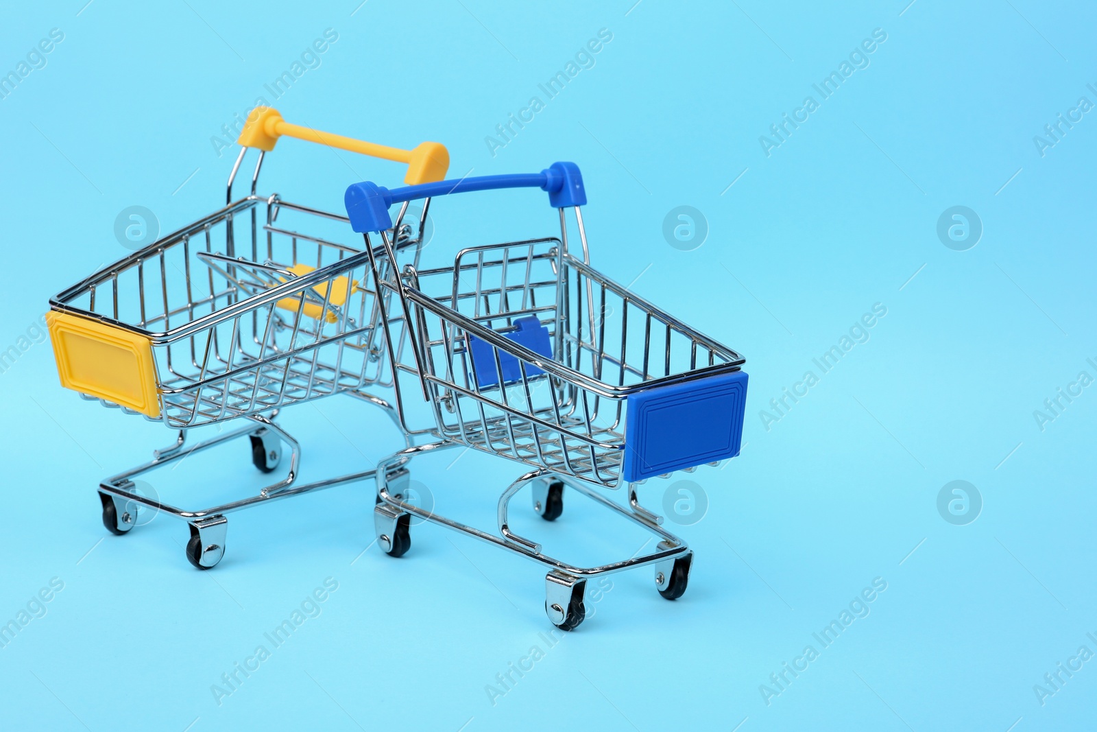 Photo of Empty shopping trolleys on color background. Space for text