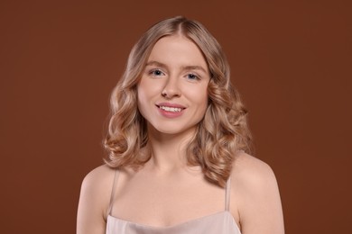 Photo of Portrait of beautiful woman with blonde hair on brown background