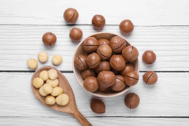 Photo of Delicious organic Macadamia nuts on white wooden table, flat lay