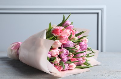 Photo of Bouquet of beautiful tulips on grey wooden table