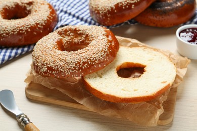 Photo of Delicious fresh bagel with sesame seeds on light wooden table