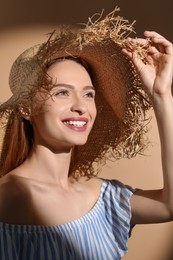 Photo of Beautiful young woman in sunlight on beige background