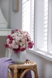 Photo of Beautiful bouquet on wooden stand near window indoors