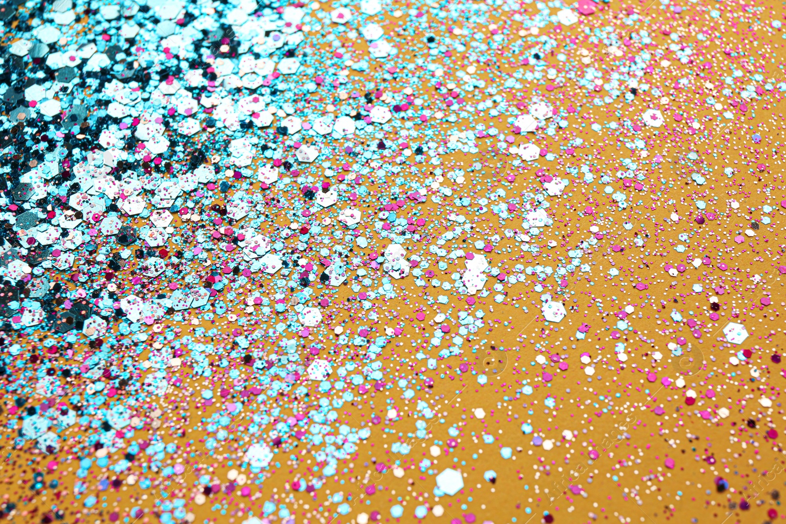 Photo of Shiny bright light blue glitter on yellow background