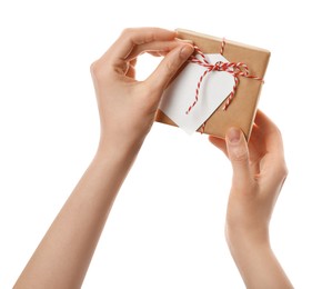 Photo of Woman holding parcel wrapped in kraft paper with tag on white background, closeup